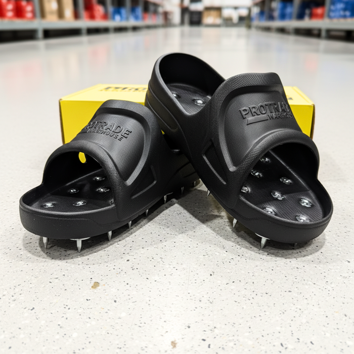Black cleated sandals with a yellow ProTrac box on a concrete floor.