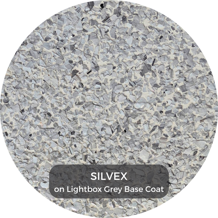 Round color swatch of epoxy flake labeled 'SILVEX on Lightbox Grey Base Coat' with a textured gray pattern.
